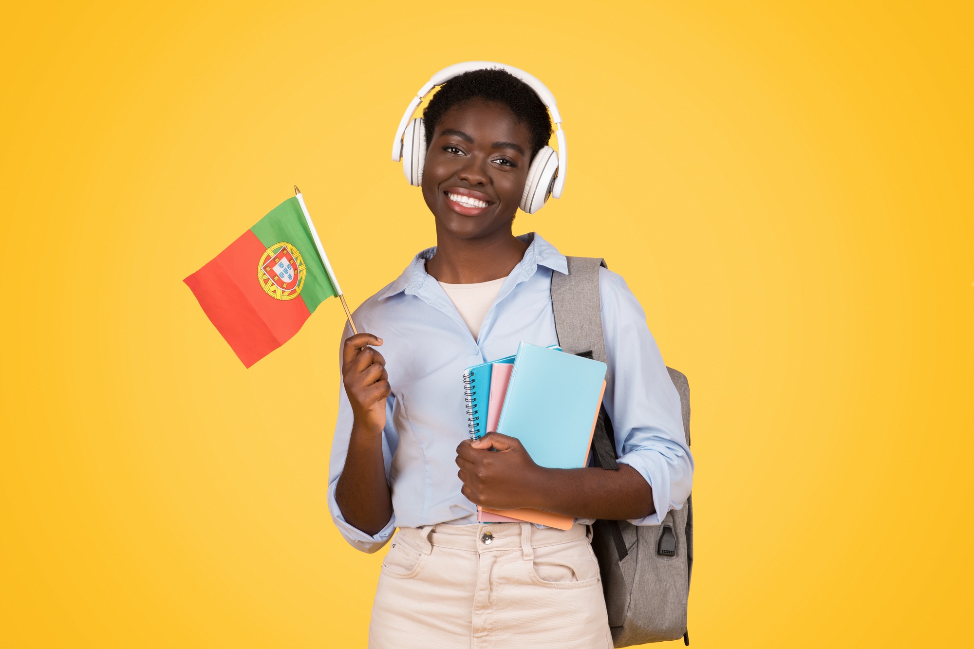 Happy teen african american lady student in wireless headphones, with books