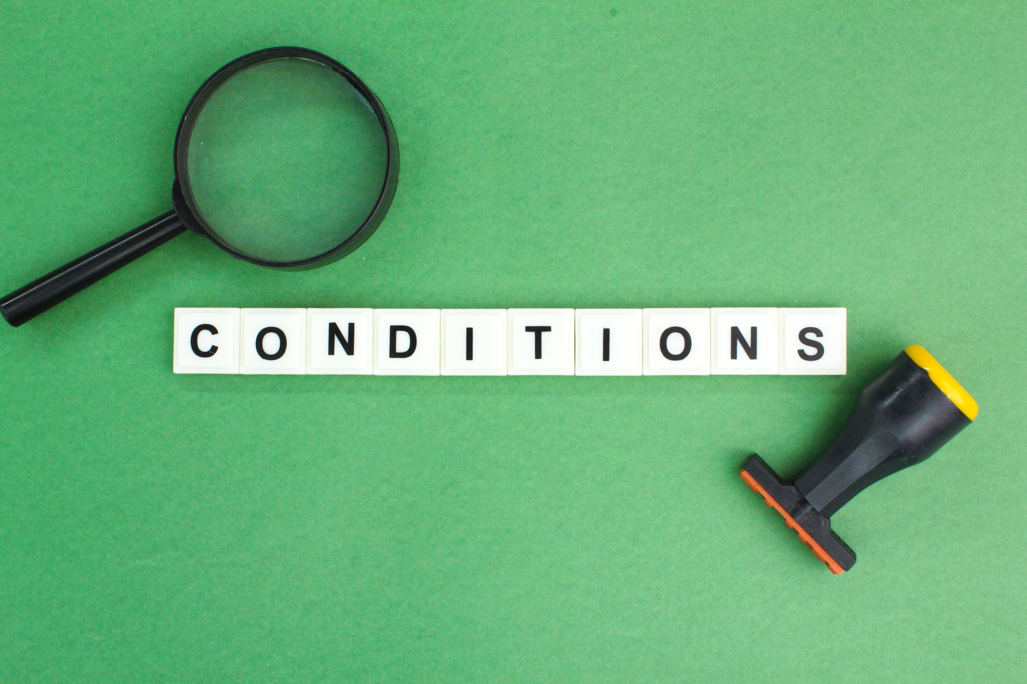 magnifying glass and stamp with the word conditions.