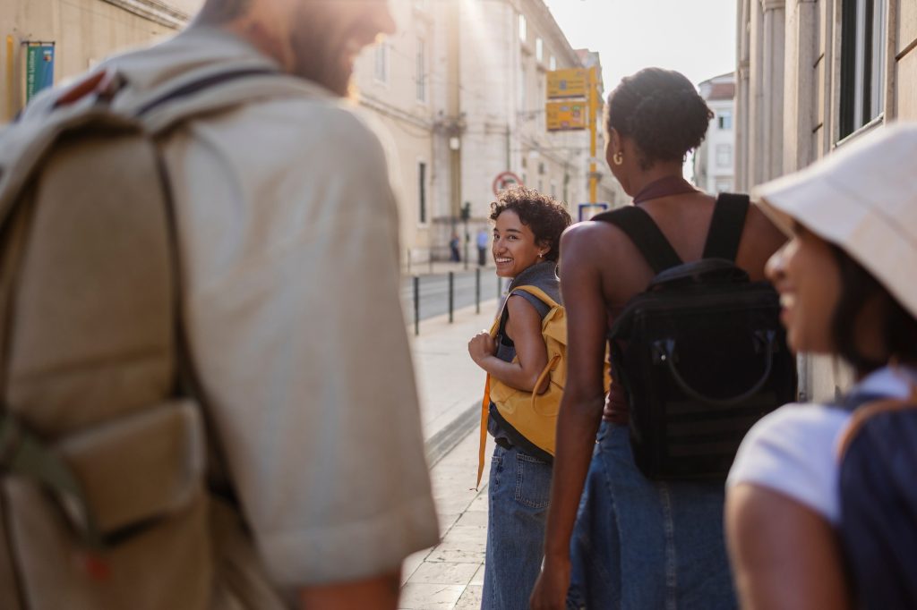 Tourists walking down sunny street in lisbon, portugal, enjoying their vacation